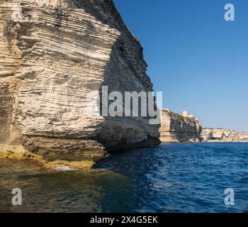 Bonifacio, Corse-du-Sud, Corsica, Francia. Vista dall'angolo basso dal mare delle aspre scogliere calcaree di Pointe du Timon. Foto Stock