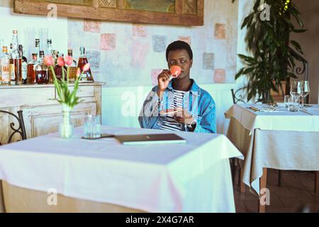 la giovane donna africana dai capelli corti ha il caffè espresso Foto Stock