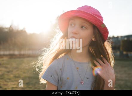 ragazza che soffia bollicine in giardino al tramonto Foto Stock