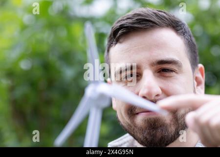 giovane uomo con il modello di mulino a vento in mano Foto Stock