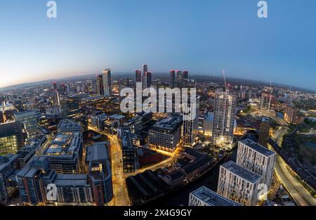 Il paesaggio notturno di Manchester con gru da costruzione Foto Stock