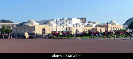 Mascate, Oman - 2 gennaio 2024: I primi visitatori ammirano la bellezza architettonica del Palazzo reale circondato da colori vivaci e cieli limpidi. Foto Stock