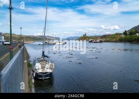 Guardando a est lungo Loch Alsh dal porto di Kyleakin, l'Isola di Skye. Barche da pesca nel porto. Mostra il castello di Moil in rovina. Skye, Highlands, Scozia, regno unito Foto Stock