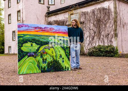 Haddington, Regno Unito. 3 maggio 2024 nella foto: Artista, Joe Grieve con il suo dipinto Colstoun, che mostra i terreni della tenuta fuori Colstoun House. Colstoun Arts è una nuova impresa a Colstoun House a Haddington, fuori Edimburgo. Si tratta in parte di diversificazione e di nuovi modi per sostenere una casa di campagna, e in parte di iniziare il viaggio verso la loro visione - diventare un museo nazionale per l'arte del paesaggio. La prima mostra presso la sede, The Other Side, presenta opere su larga scala di Landscape Painter, Joe Grieve. Crediti: Rich Dyson/Alamy Live News Foto Stock