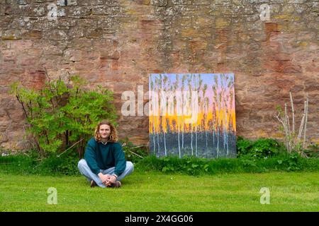 Haddington, Scozia, Regno Unito. 3 maggio 2024. L'artista paesaggista Joe Grieve espone i suoi dipinti a Colstoun House vicino a Haddington. La sua mostra segna l'apertura della prima mostra di Colstoun Arts che una nuova avventura, in parte sulla diversificazione e nuovi modi per sostenere una casa di campagna, e in parte sull'inizio del viaggio verso la loro visione - per diventare un museo nazionale per l'arte del paesaggio. Artista PIC Joe Grieve con dipinto End of the Road. Iain Masterton/Alamy Live News Foto Stock