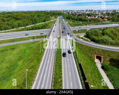 Incrocio multilivello dell'autostrada cittadina con l'autostrada A4 a Cracovia, Polonia. Auto, traffico, rampe, sentiero sotterraneo e pista ciclabile. Vista aerea. Città i Foto Stock