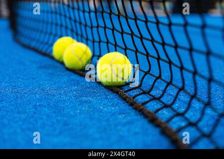 diverse palle in rete su un campo da tennis blu paddle Foto Stock