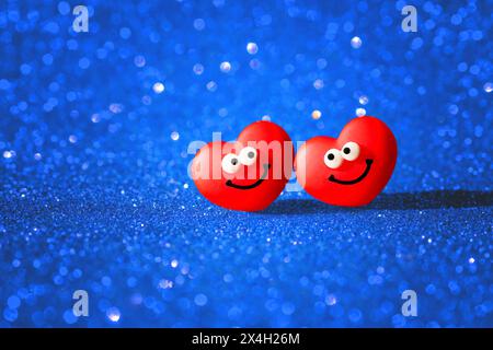 Due simpatici personaggi antropomorfi di cuore ambientati su uno sfondo blu scintillante. Biglietto di San Valentino che irradia amore e felicità. Foto Stock