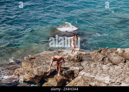 Nizza, Francia - 26 agosto 2023: Gente sulla spiaggia rocciosa di Nizza Foto Stock