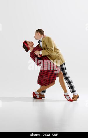 Elegante giovane coppia uomo e donna in un elegante abito d'epoca che danzava con danza retrò isolata su sfondo bianco dello studio Foto Stock