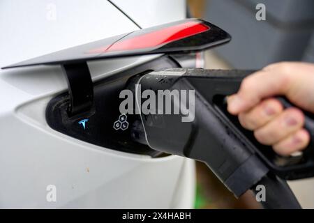 Italia - 1 maggio : la persona inserisce una spina o un cavo di ricarica / spina di ricarica di una stazione di ricarica per auto elettriche in un veicolo elettrico per caricare la batteria per il viaggio *** persona steckt einen Stecker bzw. Ladekabel / Ladestecker einer Ladesäule für Elektroautos in ein Elektrofahrzeug um die batterie bzw. Den Akku zu laden für die Fahrt Foto Stock