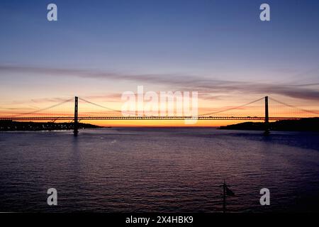 06.40: Alba sul ponte del 25° anniversario, fiume Tago, Lisbona, vista da una nave da crociera in avvicinamento, aprile 2024. Foto Stock