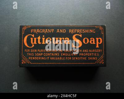 Circa 1910 – una scatola antica fatta per contenere il sapone Cuticura, risalente all'inizio del XX secolo. La scatola è decorata con un audace design nero e arancione che incorpora lo slogan, "sapone Cuticura fragrante e rinfrescante per la purificazione della pelle, il WC, il bagno e il vivaio - questo sapone contiene proprietà emollienti che lo rendono prezioso per le pelli sensibili". Fondata nel 1865, la sapone Cuticura è stata originariamente prodotta a Boston, Massachusetts dalla Potter Drug and Chemical Corporation. Foto Stock