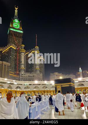 La Mecca, Arabia Saudita - 7 marzo 2023: Moltitudine di pellegrini che camminano per la Kaaba durante l'Hajj in Mecca - la città più sacra dell'Islam - foto serale con buio Foto Stock