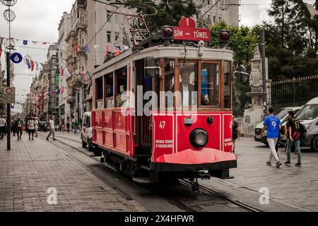 il tipico e storico tram rosso corre lungo la strada dello shopping di istanbul Foto Stock