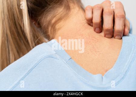 La bambina con una camicia rosa e le cuffie è scioccata e sorpresa da ciò che vede mentre fissa il suo telefono cellulare Foto Stock