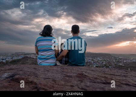 isolare la coppia con bambini che guardano il paesaggio della città sulla cima della montagna con un cielo spettacolare al crepuscolo immagine scattata a mehrangarh jodhpur rajasthan india. Foto Stock