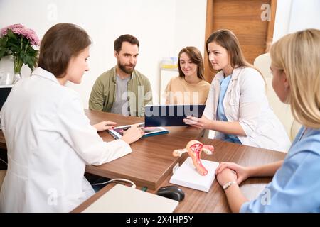 Riunione ginecologica medica revisione risultati di esame giovane donna incinta Foto Stock