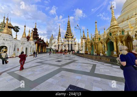 Shwedagon Pagoda, Yangon, Myanmar, Asia, le persone visitano e pregano in un cortile del tempio con la tradizionale architettura birmana Foto Stock