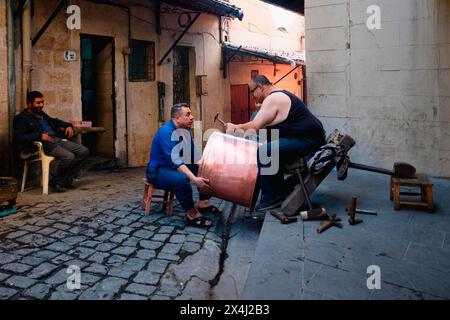 Fabbro al lavoro su un bacino di rame, il bazar Gaziantep, Turchia Foto Stock