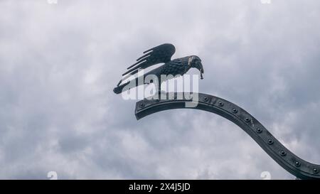 BUDAPEST/UNGHERIA - 2023-05-06: Corvo con un anello nel becco alla porta del castello di Buda Budapest, Ungheria Foto Stock