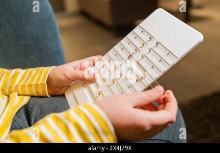 Primo piano di un bambino che tiene in mano un orecchino in una gioielleria sullo sfondo Foto Stock