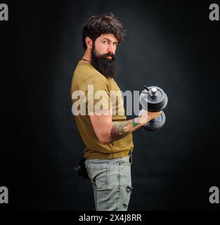 Allenamento sportivo muscoloso con barba forte e manichino. Culturisti che pompano muscoli con il manubrio. Sollevamento pesi. Manubrio per il sollevamento di un atleta muscoloso Foto Stock