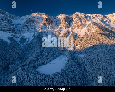 L'alba sulla catena montuosa della Serra del Cadí e Prat de Cadí dopo una nevicata e con la Luna calante (Cerdanya, Catalogna, Spagna, Pirenei) Foto Stock