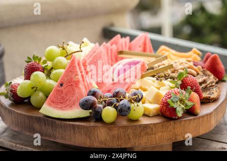 Tavola rotonda di salumi di frutta mista con spicchi di anguria davanti all'uva. Foto Stock