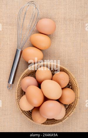 Uova biologiche fresche nel cestello a trama sullo sfondo del sacco. Foto Stock