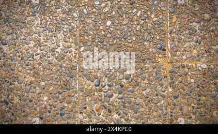 Superficie ruvida della finitura di aggregato esposta, pavimento lavato in pietra, realizzato in piccola pietra arenaria di colore marrone chiaro Foto Stock