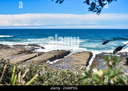 promontorio roccioso con enormi onde che si infrangono Foto Stock