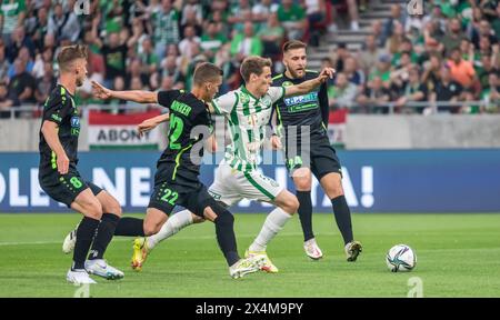 Budapest, Ungheria – 11 maggio 2022. Il centrocampista del Ferencvaros Kristoffer Zachariassen con i giocatori dei Paks Balasz Balogh, Jozsef Windecker e Bence Lenzser Foto Stock