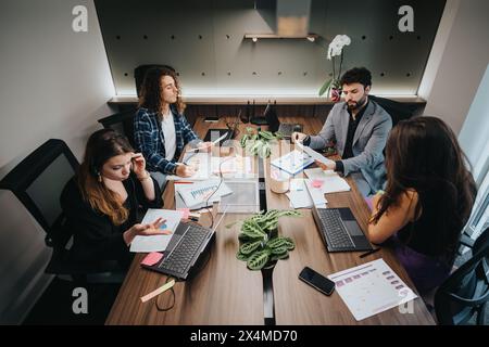 Team diversificato di professionisti impegnati in una sessione di pianificazione strategica in un ufficio moderno Foto Stock