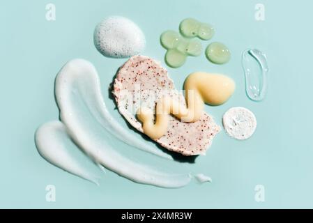 I prodotti cosmetici di bellezza macchiano la consistenza della crema su sfondo blu. Set di vari campioni per la cura della pelle, schiuma, balsamo, gel e creme. Foto Stock