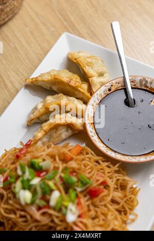 Mescolare spaghetti, gnocchi e salsa piccante su un piatto bianco, cucina asiatica Foto Stock