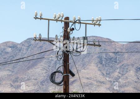 Vecchi raccordi bianchi in bachelite su un palo del telegrafo con cavi sostituiti con un cavo in fibra. Foto Stock