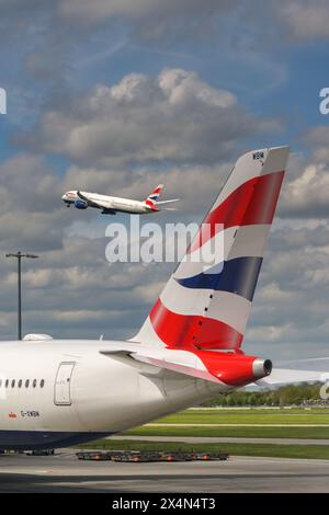 Londra, Inghilterra, Regno Unito - 29 aprile 2024: Pinna di coda di un jet Airbus A350 della British Airways. Sullo sfondo, un altro aereo della compagnia aerea sta decollando Foto Stock