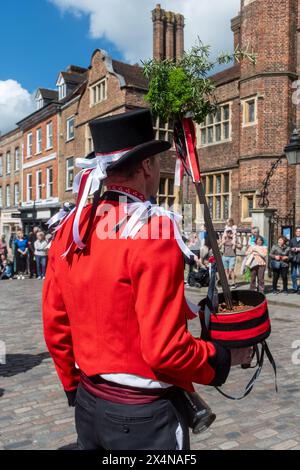 4 maggio 2024. Il Guildford Summerpole Festival si è svolto oggi nel centro della città. L'evento annuale gestito dai ballerini Guildford Pilgrim Morris prevede una processione fino alla High Street, esibizioni di morris danzanti da diversi gruppi, seguite dall'erigere il palo estivo (invece di un tradizionale maypole) nei terreni del castello di Guildford e ulteriori danze. Il Barker che porta la torta della fertilità. Foto Stock