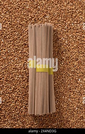 Spaghetti crudi di grano saraceno soba in fascio su grano. Dieta vegana sana. Pasta alternativa senza glutine. Foto Stock