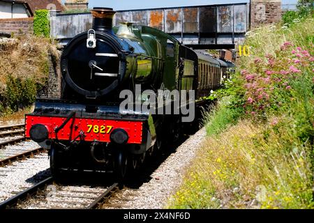 Lydham Manor No. 7827 una locomotiva a vapore 4-6-0 sulla ferrovia a vapore di Dartmouth che passa sotto un ponte stradale sulla sua strada da Paignton a Kingswear in so Foto Stock