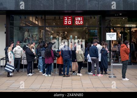 Gli acquirenti fanno la fila fuori dal rivenditore di moda giapponese Uniqlo in Princes Street, Edimburgo, Scozia, Regno Unito. Foto Stock