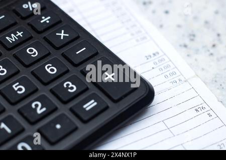 Primo piano di una calcolatrice, di un dispositivo di input periferico, sopra un foglio di carta, di un'apparecchiatura da ufficio spesso utilizzata con una tastiera per computer o un personal com Foto Stock