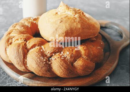 Assortimento di pane bianco. Kalach e Challah fatti di farina di grano su tavola con latte. Foto Stock