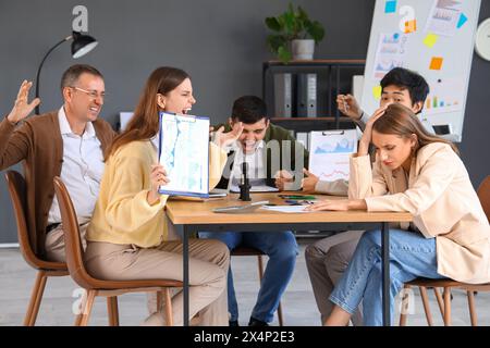 Giovane donna d'affari che soffre di colleghi rumorosi in ufficio Foto Stock