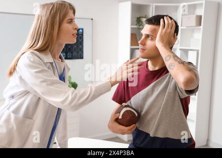 Medico donna che esamina la giocatrice di rugby con commozione cerebrale in clinica Foto Stock