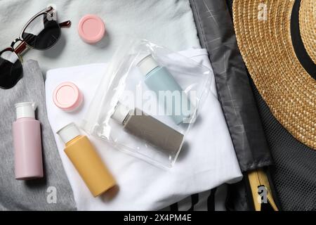 Kit cosmetico da viaggio, sacchetto di plastica e accessori in valigia, vista dall'alto Foto Stock