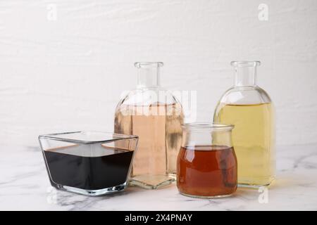 Diversi tipi di aceto su tavolo in marmo chiaro, primo piano Foto Stock