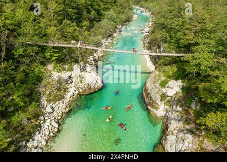 Un ponte sospeso attraversa le acque color smeraldo del fiume Soca in Slovenia Foto Stock