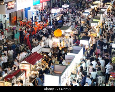 NANNING, CINA - 4 MAGGIO 2024 - foto aerea scattata il 4 maggio 2024 mostra i turisti che si riuniscono davanti alle bancarelle in un mercato notturno a Nanning, Cina meridionale Foto Stock